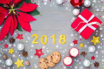 Xmas symbol on gray wooden background. Christmas decoration with poinsettia christmas, stars, coockies and candles.