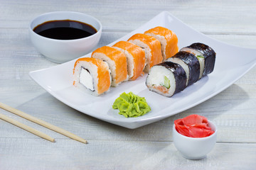 Philadelphia roll sushi with wasabi and soy on white plate. Sushi menu. Japanese food. 