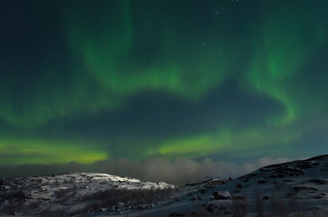 Obraz na płótnie Canvas Northern lights, aurora over hills and tundra in the winter.