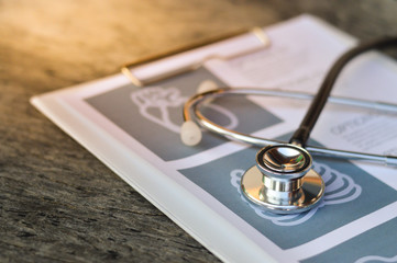 Stethoscope and pen on report pad ,health and medical concept ,selective focus.