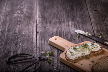 bread with curd cheese and herbs, wooden background horizontal