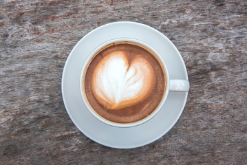 Top view of hot coffee latte on wood table background.