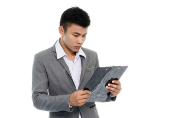Portrait of a young business man reading annual report. Isolated on white background