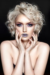 Beautiful woman portrait on black background with violet and silver glamour make up and curly hair.