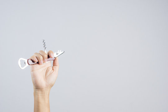 Hand holding pocket universal bottle opener with short knife for multi functions