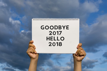 Hands holding a placard paper with word - Goodbye 2017 Hello 2018.
