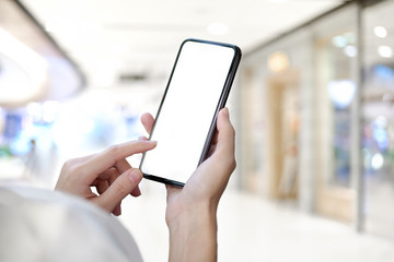 Cropped shot of an unrecognizable businesswoman using a mobile phone at office. Blank screen smart phone for graphic display montage.