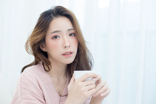 Asian Woman holding coffee cup at bedroom. People lifestyle concept.