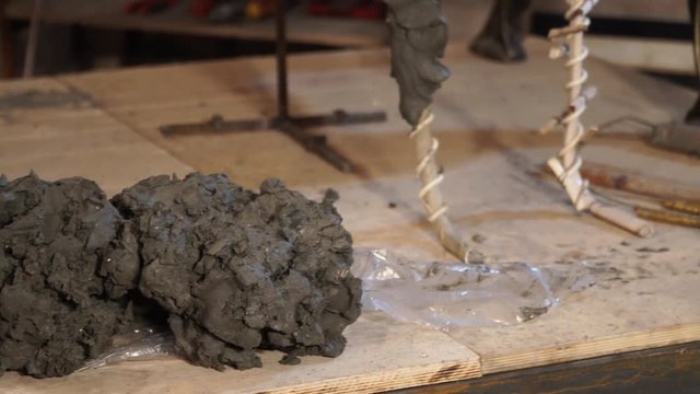 the sculptor is working on the creation of a monument - the process of making a monument in full growth from clay – 4k video