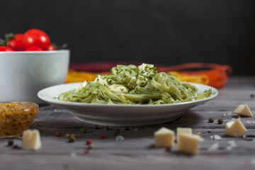 pasta green with spinach and mozzarella cheese and greens in a white plate, French mustard, colored...