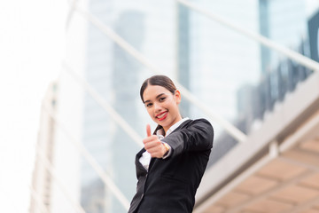 Happy smiling business woman with thumbs up gesture