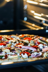 Naklejka na ściany i meble pizza with mushrooms, ham and mozzarella cooked baking in the oven