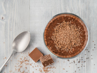 Chocolate chia pudding in glass on gray table