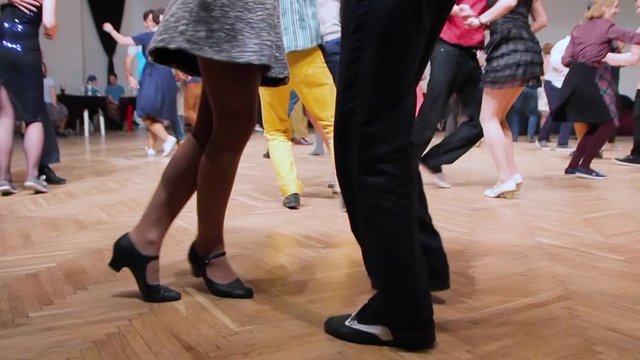 Dancers perform lindy hop dance at the swing festival. Dancing legs close up.