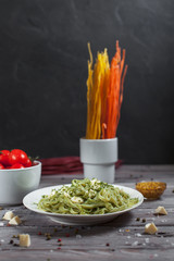 pasta green with spinach and mozzarella cheese and greens in a white plate, French mustard, colored...