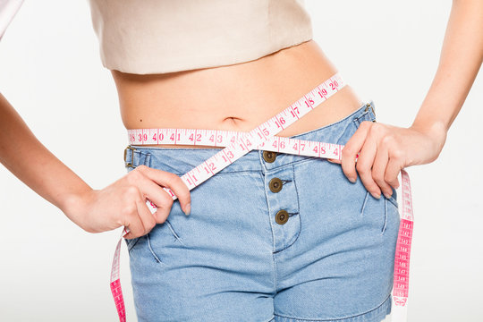 Close Up Woman measuring her waistline with measure line