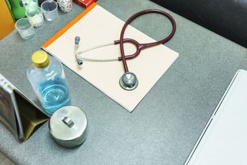 Stethoscope and patient's profile on the table in the local clinic , Thailand