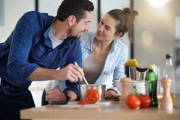 Photo sur Plexiglas Cuisinier Couple at home having fun cooking together
