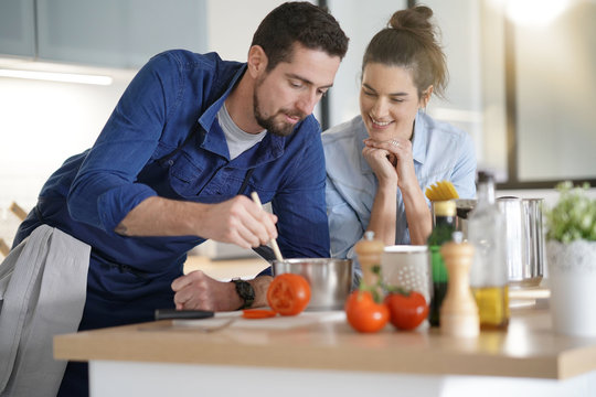 Couple at home having fun cooking together