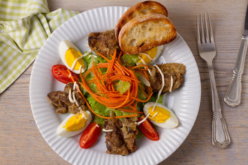 Chicken liver, carrot, eggs, tomatoes, lettuce and fried onion salad. Liver and vegetables. Top, overhead, above view, horizontal