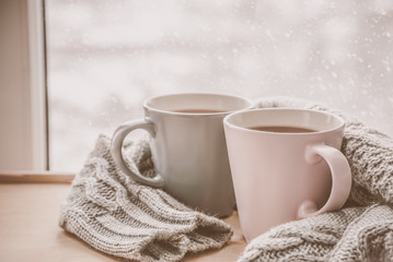 Fototapeta na wymiar Valentine's day concept - two cups of tea in front of snow background