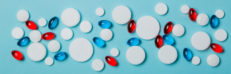Medical concept - different shape white, red, blue pills on blue background