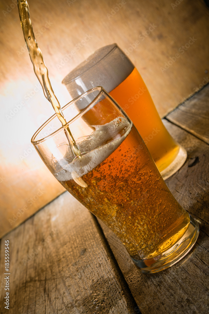 Wall mural Beer in frosty mugs on rustic background