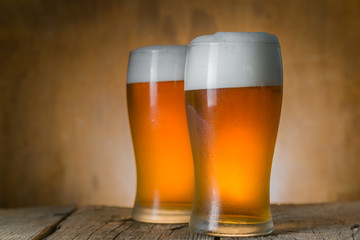 Beer in frosty mugs on rustic background