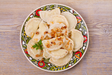 Dumplings, filled with potato and served with fried onion. Varenyky, vareniki, pierogi, pyrohy. overhead