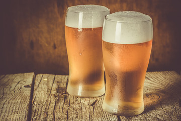 Beer in frosty mugs on rustic background