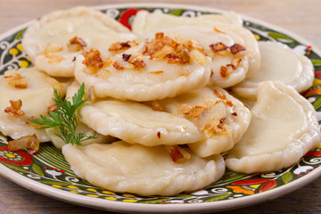 Dumplings, filled with potato and served with fried onion. Varenyky, vareniki, pierogi, pyrohy