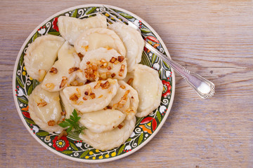 Dumplings, filled with potato and served with fried onion. Varenyky, vareniki, pierogi, pyrohy. overhead