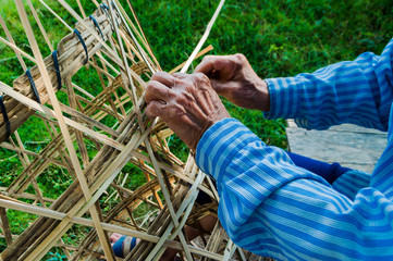 The basket-maker,Weave pattern hand bamboo, Bamboo weaving,Basket weaving , a village industry in thailand,Old Man's hands making a wicker basket