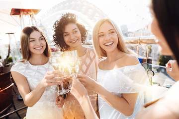 Bachelorette party. Positive delighted happy women standing together and drinking champagne while having a celebration
