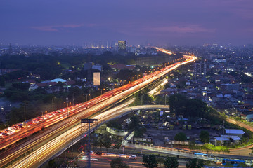Cityscape of Jakarta city at night with the glitter of lights vehicles, buildings, and houses residents.