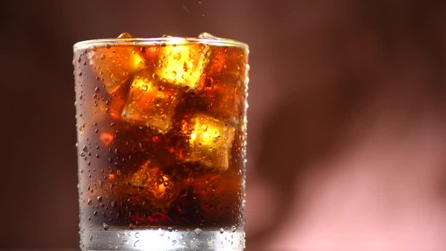 Coke with ice cubes background. Rotation 360 degrees. 4K UHD video footage. Ultra high definition 3840X2160
