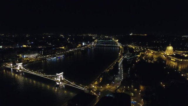 Chain bridge and Buda Castle in Budapest aerial approach at night, Budapest, Hungary