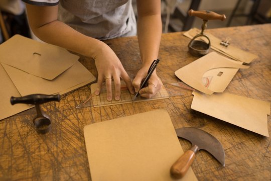 Worker marking on leather in workshop