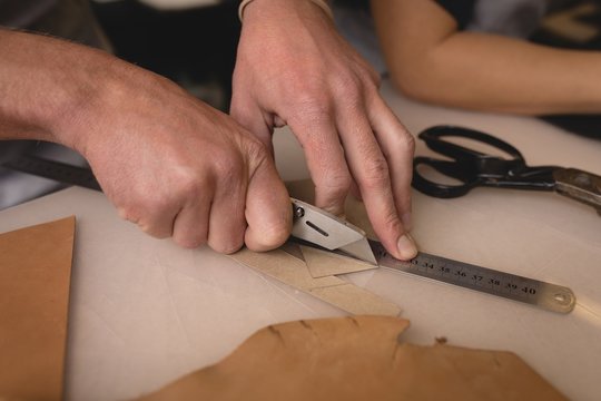 Worker cutting a leather with cutter