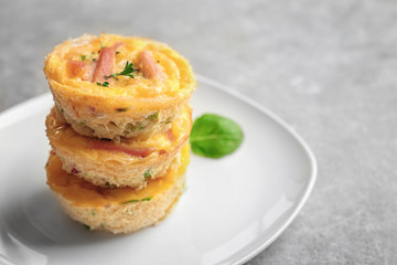 Plate with stack of tasty egg muffins on table