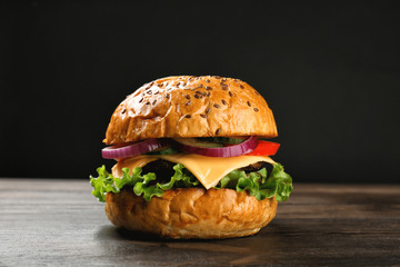 Tasty burger on wooden table