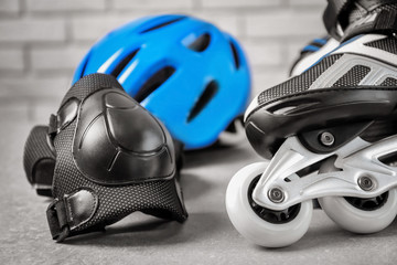 Roller skate and knee pad on floor, closeup © Africa Studio