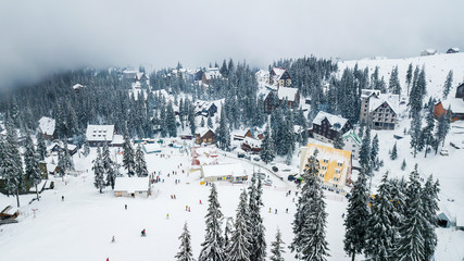 Fototapeta na wymiar Snow-covered ski resort in the mountains with Christmas trees