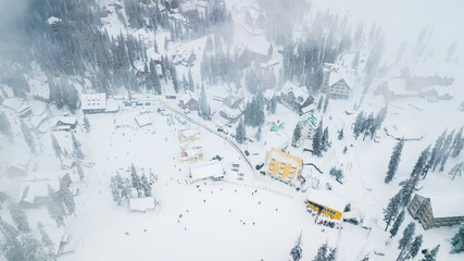 Snow-covered ski resort in the mountains with Christmas trees