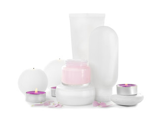 Different cosmetic products and candles on white background