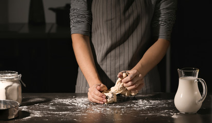 Obraz na płótnie Canvas Woman kneading dough on table