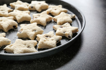 Plate with raw cookies on dark background