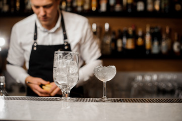 Two glasses filled with ice cubes arranged on the bar counter