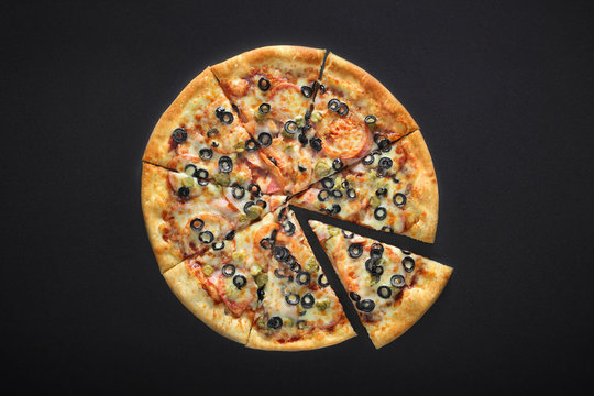 pizza barbecue with cornichoni olives peperoni cheese mozzarella on black stone background