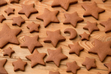 Christmas gingerbread cakes in shape of stars on rustic wooden table.